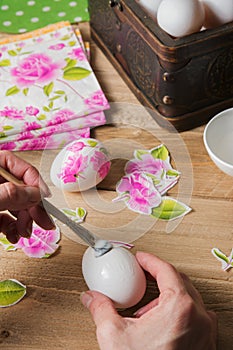 Woman apply glue on colored Easter egg. decoupage