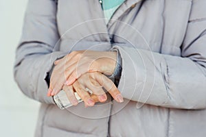 Woman applying alcohol spray against coronavirus. Closeup of female hand disinfecting hands with antiseptic spray, outdoors