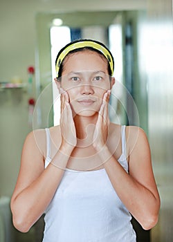 Woman applying aloe vera cream to face