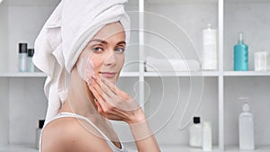 Woman applying anti-aging mask on face. Medium close up shot on 4k RED camera