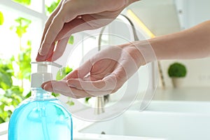 Woman applying antibacterial soap indoors. Personal hygiene during COVID-19 pandemic photo