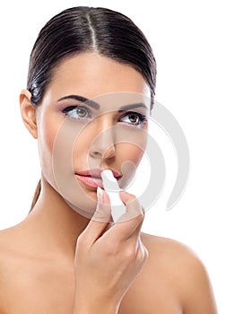 Woman applying balsam on lips