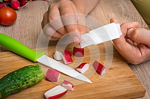 Woman is applying band aid plaster on her finger