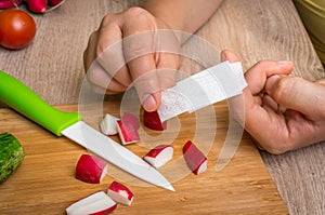 Woman is applying band aid plaster on her finger