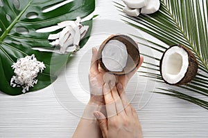 Woman applying body cream with coconut extract