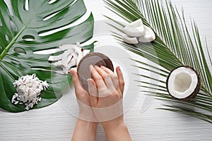 Woman applying body cream with coconut extract