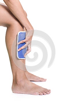 Woman applying cold pack on swollen hurting shin