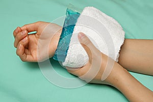 A woman applying cold pack on swollen hurting wrist