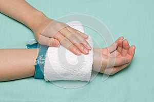 A woman applying cold pack on swollen hurting wrist