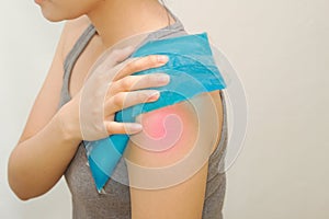 Woman applying cold pack on swollen shoulder