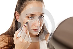 Woman applying concealer