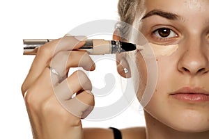 Woman applying concealer