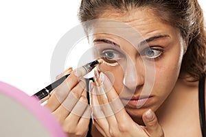 Woman applying concealer