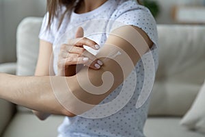 Woman applying cream on arm using natural treatment closeup view photo