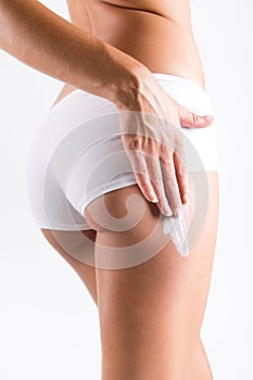Woman applying cream on legs