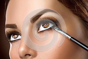 Woman applying eye makeup closeup