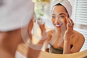 Woman applying eye mask on dark circles
