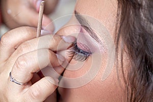 Woman applying eyelashes