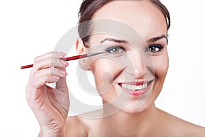 Woman applying eyeliner with brush