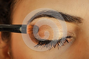 Woman applying eyeshadow on her eyes