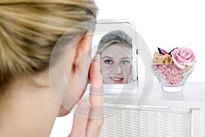 Woman applying facepack in mirror