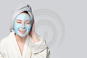 Woman applying facial clay mask at spa salon or at home, skincare theme. Face mask, spa beauty treatment with copy space