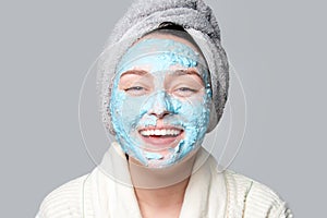 Woman applying facial clay mask at spa salon or at home, skincare theme. Face mask, spa beauty treatment with copy space