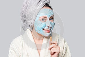 Woman applying facial clay mask at spa salon or at home, skincare theme. Face mask, spa beauty treatment with copy space