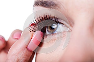 Woman applying false eyelashes photo