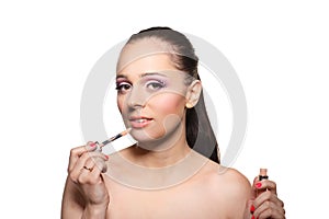 Woman applying gloss for lips.