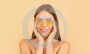 Woman applying golden eye patches. Close up portrait girl. Portrait of beauty woman with eye patches showing an effect