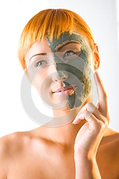 Woman applying green mask