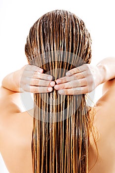 Woman applying hair conditioner. Isolated on white.