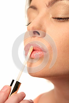 Woman applying lip gloss photo