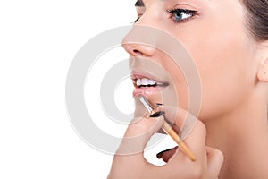 Woman applying lip gloss with brush