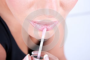 Woman applying lipgloss photo