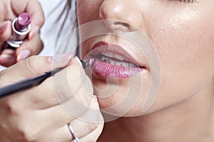 Woman applying lipstick photo