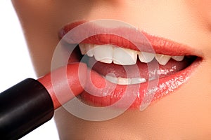 Woman applying lipstick beauty cosmetics to lips photo