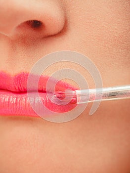 Woman applying lipstick with brush on lips. Makeup