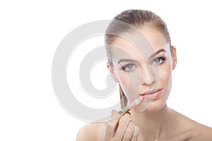 Woman applying lipstick, isolated on a white background