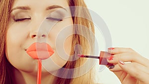 Woman applying lipstick or lip gloss