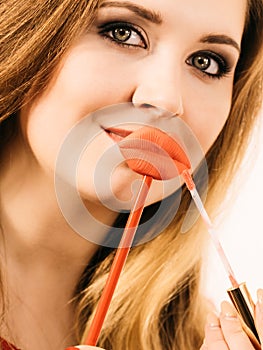 Woman applying lipstick or lip gloss