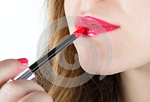 Woman applying lipstick to lips