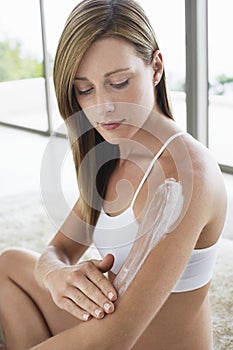 Woman Applying Lotion On Arm