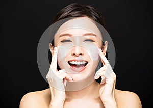 Woman applying lotion cream on face