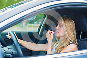 Woman applying make-up while driving car.