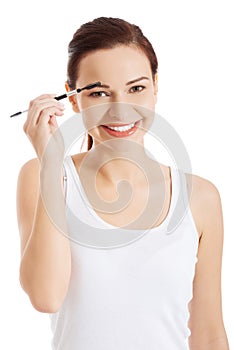 Woman applying make up on her eyebrow