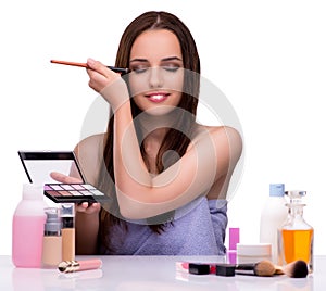 Woman applying make-up isolated on white