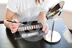 Woman applying make up photo