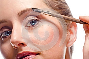 Woman applying make-up using eyebrow brush